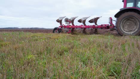 Tractor-Agrícola-Arando-El-Campo-En-Letonia---Tiro-Estático-De-Bajo-Nivel