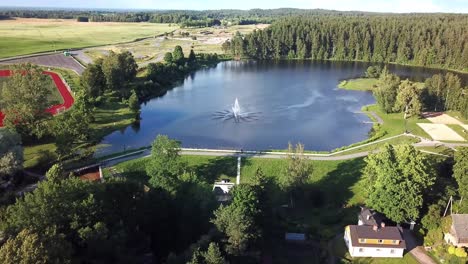 Flyaway-Drone-Shot-of-Recreation-Complex-next-to-Lake-with-Fountain---Ascending-Aerial-View