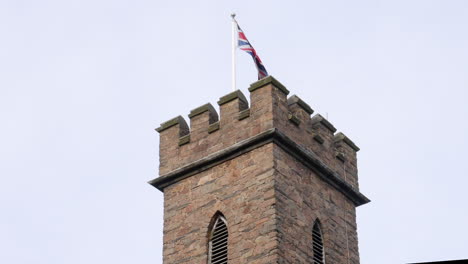Ein-Britischer-Schlossturm-Zeigt-Eine-Gewerkschaftsflagge,-Die-Auch-Als-Union-Jack-Bekannt-Ist
