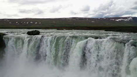 Drone-Flying-Over-The-Ridge-Of-Godafoss-Waterfall-In-Northern-Iceland-On-A-Cloudy-Day---low-aerial