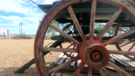 Old-red-wagon-wheel-in-a-yard-during-a-sunny-day