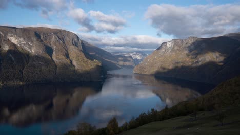 Ein-Blick-Auf-Einen-Fjord-Mit-Sich-Bewegenden-Wolken-Und-Lämmern-Im-Vordergrund