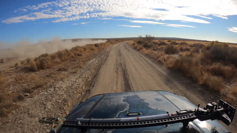 POV-racing-in-desert-landscape-behind-dust-trail-of-faster-vehicle