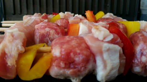 Delicious-skewers-on-grill,-chicken,-sausage-and-pepper,-handheld,-shift-focus