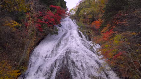 Wunderschöne-Wasserfälle,-Umgeben-Von-Leuchtend-Roten-Und-Orangefarbenen-Herbstblättern
