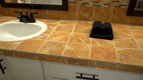Bathroom-sinks-with-dark-brown-faucets-and-mosaic-tile-countertop-and-backsplash