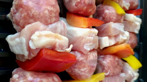 Vertical-view-of-raw-skewers-on-grill,-chicken,-sausage-and-pepper,-static