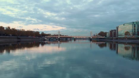 dolly-forward-rising-reveal-drone-shot-of-Albert-bridge-and-London-city-at-sunset