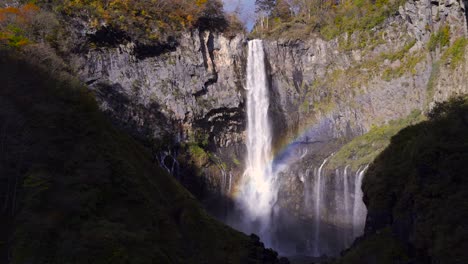Atemberaubender-Wasserfall,-Der-Zwischen-Hohen-Felsen-Fällt-Und-Einen-Regenbogen-Bildet