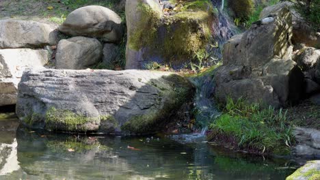 Beruhigender-Wasserfall,-Der-Aus-Felsen-Im-Exotischen-Koreanischen-Tempelgarten-Fließt