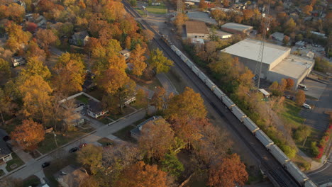 Aerial-view-of-a-freight-train-pulling-down-the-tracks-through-Kirkwood-in-St
