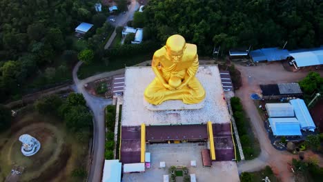 4k-Luftbild-Von-Oben-Nach-Unten-Auf-Die-Goldene-Statue-Von-Luang-Pu-Thuat-Im-Morgengrauen