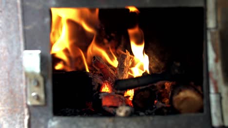 Flames-of-fire-dancing-wildly-in-an-old-rusty-fireplace,-SLOW-MOTION