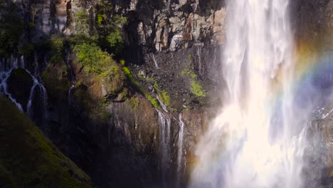 Unglaubliche-Aussicht-Auf-Den-Wasserfall-Mit-Regenbogen,-Der-Grüne-Klippen-Hinunterfällt