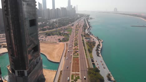 Aerial-tilt-down-shot-of-a-motorway-in-Abu-Dhabi-near-the-skycrapers