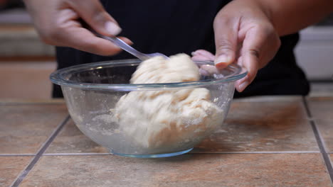 Black-Woman-Stirs-Khorasan-Wheat-Flour-Dough-in-Glass-Bowl,-Closeup