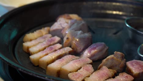 Man-Cooking-Korean-Pork-Belly-In-Hot-Iron-Grill---close-up-shot