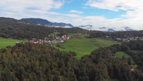 Drone-Vuela-Hacia-El-Pequeño-Pueblo-De-Montaña-Esloveno-Sentviska-Gora-A-Fines-Del-Verano