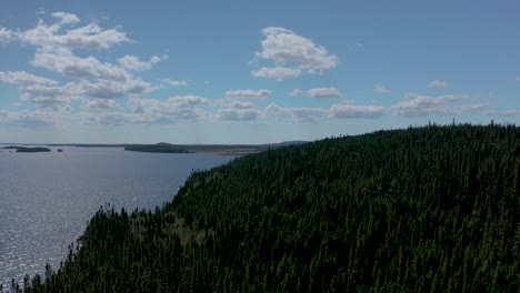 Drone-flying-over-a-forest-towards-a-beautiful-lake-in-northern-Quebec-on-a-summer-day