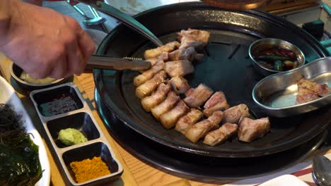 Beautiful-And-Appetizing-Spread-Of-Samgyeopsal-In-A-Grill-With-Side-Dishes---close-up-shot