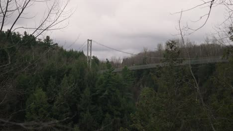 Suspended-Footbridge-Above-Coaticook-River-Valley-With-Lush-Foliage-In-Quebec,-Canada,-Rack-Focus-Shot