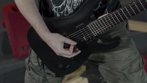 Heavy-Metal-Gitarrist-Spielt-Auf-Einer-Schwarzen-Siebensaitigen-Gitarre
