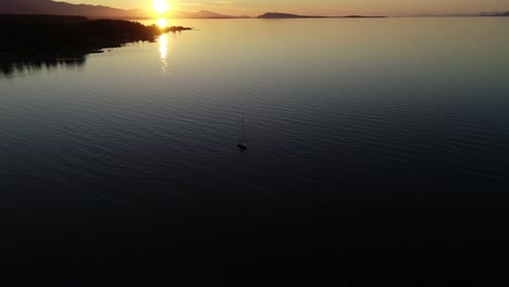 Aerial-View-of-Sunset-Above-Ocean,-Isolated-Sailing-Boat-and-Scenic-Coastline-of-Vancouver-Island,-British-Columbia,-Canada,-Static-Drone-Shot