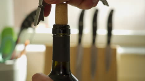 Man's-hands-pulling-a-cork-out-of-a-wine-bottle-with-a-corkscrew