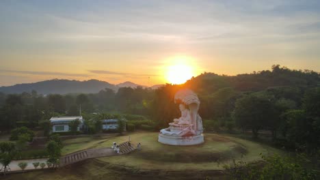 Aerial-4K-drone-footage-of-a-big-monk-statue-against-a-sunrise-backdrop-at-Khao-Yai-in-Thailand