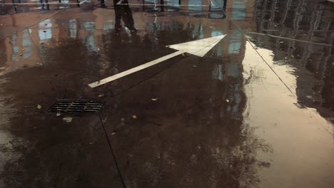 An-arrow-sign-on-the-a-concrete-floor-under-the-rain