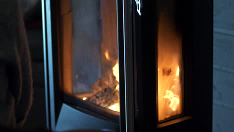 Close-slomo-tilt-down-of-fire-in-modern-wood-burning-stove-indoors