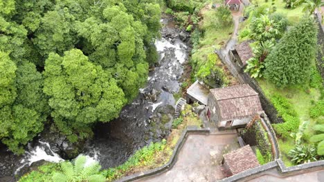 Historic-water-Mill-in-Ribeira-dos-Caldeirões-natural-park-near-cascading-waterfall---Fly-over-aerial-shot