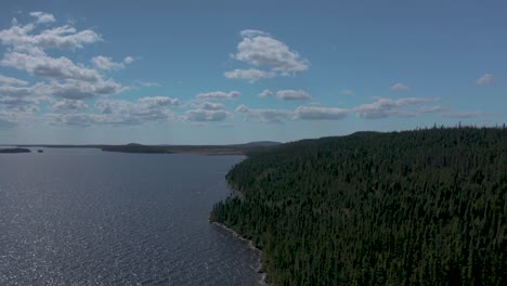Drone-flying-over-a-lake,-showing-an-isolated-dock-on-a-sunny-summer-day