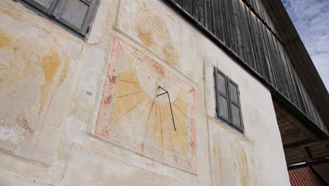 Fresco-De-Reloj-De-Sol-Pintado-En-Una-Antigua-Casa-De-Campo-En-Un-Pueblo-De-Eslovenia,-Tiro-De-Muñeca