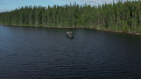 Drone-flying-around-a-fishing-boat-and-moving-away-showing-a-large-creek-on-a-beautiful-and-wild-lake