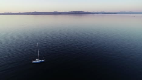 Aerial-View-of-Isolated-Sailing-Boat-in-Calm-Blue-Ocean-Water
