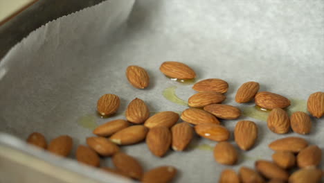 Chef-prepping-some-fresh-almonds-in-a-roasting-tray-with-some-olive-oil
