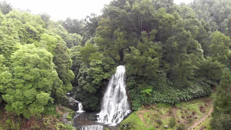 Waterfall-in-Ribeira-dos-Caldeirões-natural-park-near-Achada,-Azores,-Portugal---Ascending-aerial-shot