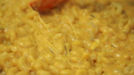 POV-closeup-video-shows-a-silicone-spatula-stirring-the-most-creamy,-rich-and-delicious-macaroni-and-cheese