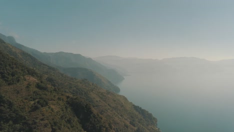 Drone-flying-over-lake-Atitlan-during-the-cloudy-morning-in-Guatemala,-Central-America