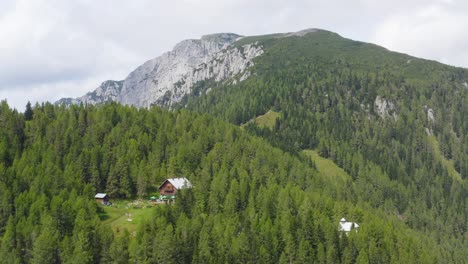 Aerial-drone-scenic-view-of-mountains-with-mountain-hut-in-foreground