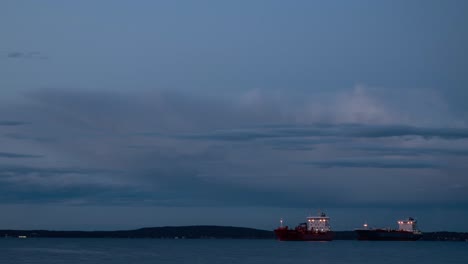 Time-lapse-video-of-two-cargo-ships-slowly-moving-at-sunset-time-in-fjord