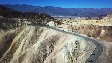 Aerial-Flyover-Of-Tourists-Walking-To-The-Top-Of-Zabriskie-Point,-Death-Valley-National-Park