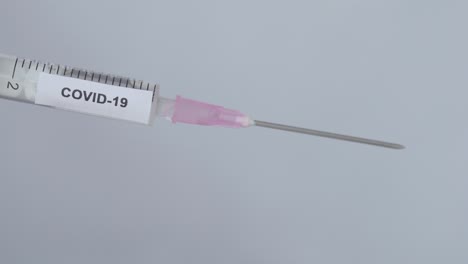 Hand-Eines-Arztes-Entfernt-Die-Nadelkappe-Der-Spritze-Mit-Covid-19-Impfstoff