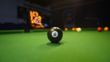 The-eight-ball-is-prominent-in-the-center-of-a-8-ball-pool-table