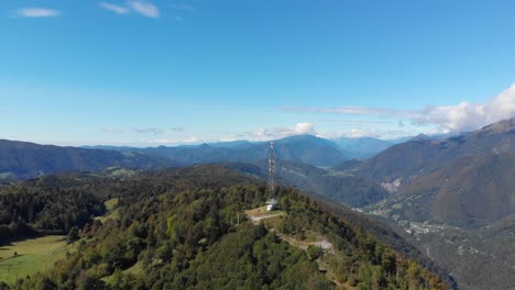Antena-De-Comunicaciones-En-La-Cumbre-Del-Vasto-Valle-Del-Pico-De-La-Montaña-Verde-Y-Exuberante-órbita-Aérea-Derecha