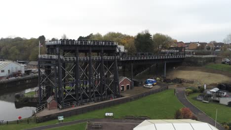 Industrial-Victorian-Anderton-canal-boat-lift-Aerial-view-River-Weaver-low-pull-back-wide-orbit-right