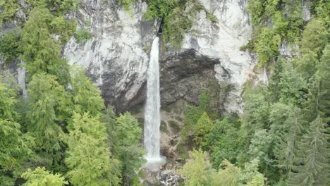 Approaching-Wildenstein-Waterfall-in-southern-Austria-between-the-forest-trees,-Aerial-dolly-in-reveal-shot