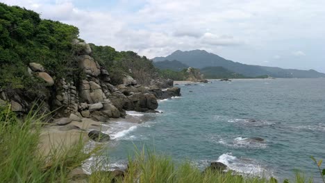 Rocky-Coastline-With-Waves-Rolling-On-Beach-In-Colombia-at-atlantic-ocean-coast-in-Tayrona-Park,-Locked-Off