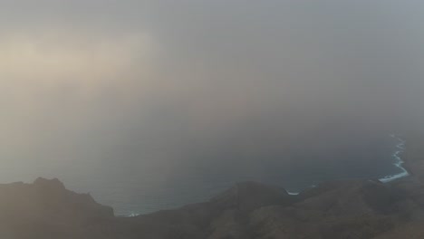 Niebla-Densa-Temprano-En-La-Mañana,-Drones-Aéreos-Que-Vuelan-Sobre-El-Paisaje-De-Los-Picos-De-Las-Montañas,-Pan-Revela-La-Salida-Del-Sol-Dorado